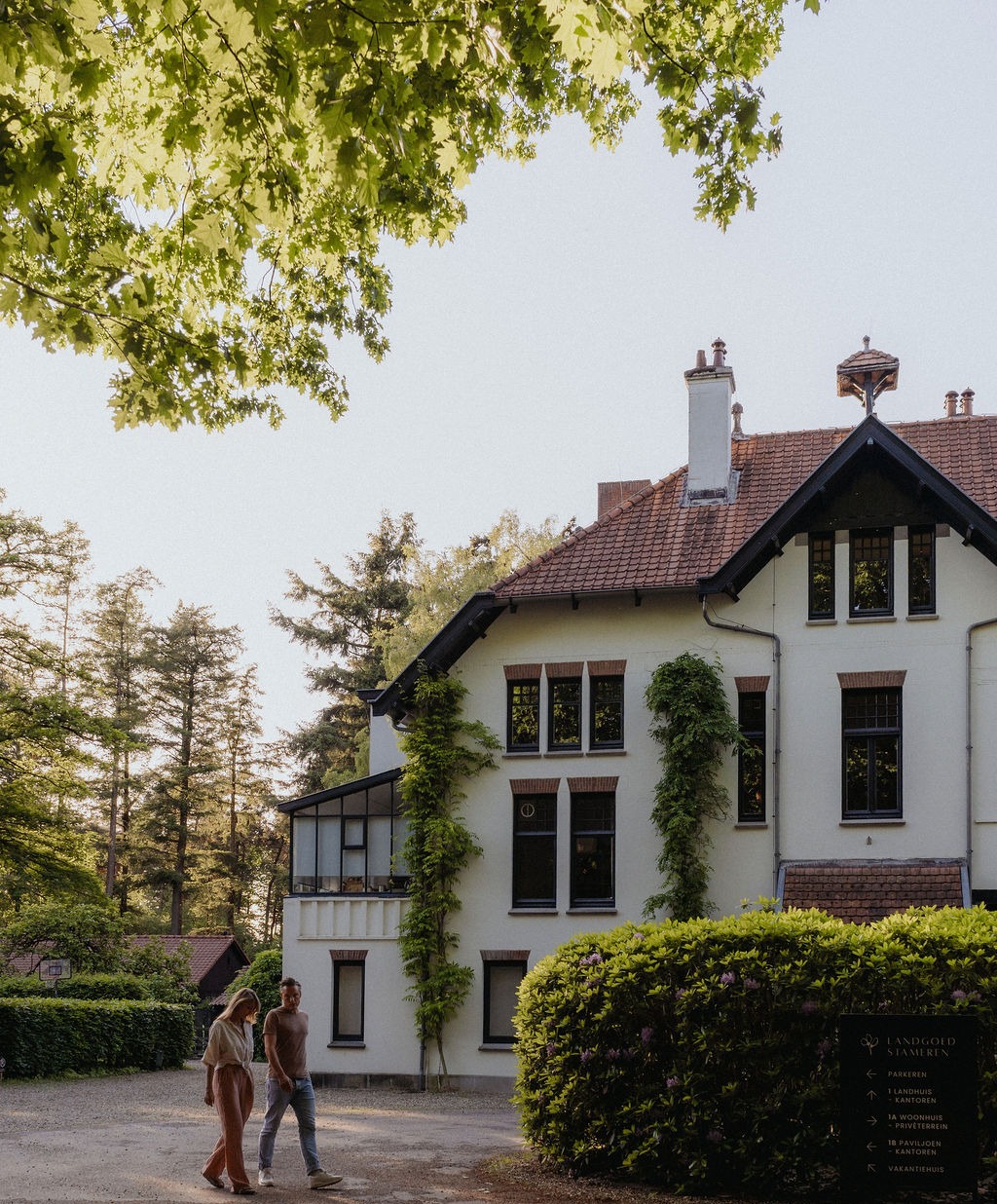 Het landhuis van het Atelier voor Liefde in Maarn, met Margo en Joris ervoor — de plek voor relatiecoaching en relatiedagen